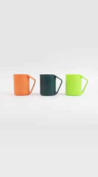 Three plastic cups in orange, dark green, and light green, each with handle