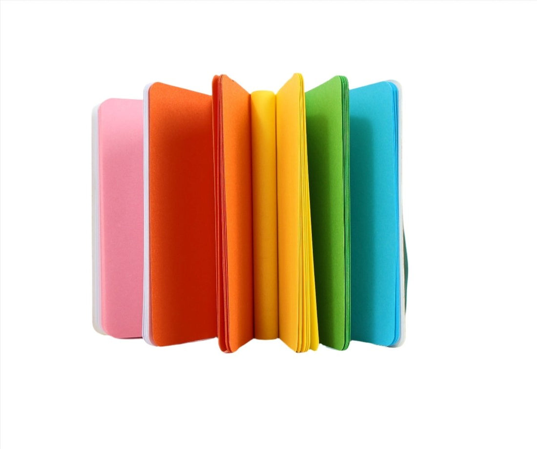 Rainbow notebook stack with pink, orange, yellow, green, and blue covers.