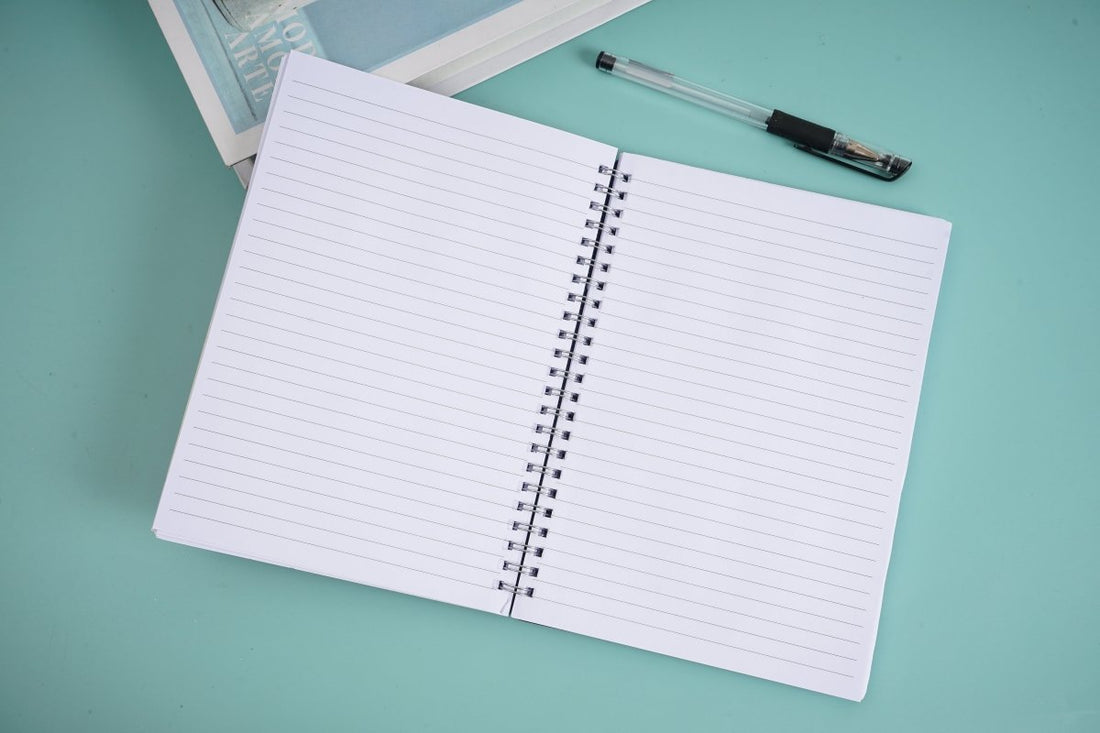 Open spiral notebook with white ruled pages and metal coil binding