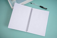Open spiral notebook with white ruled pages and metal coil binding