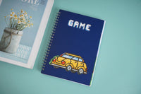 Blue spiral notebook with pixel car graphic on the cover