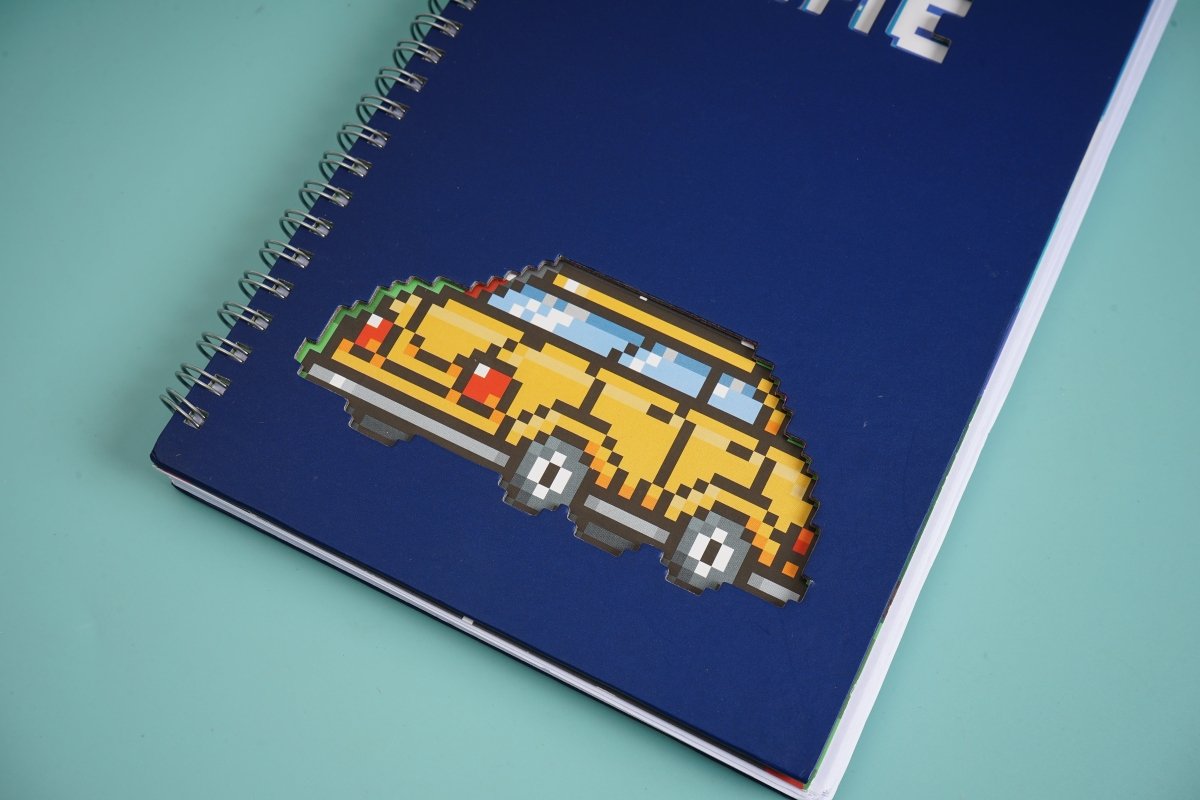 Blue spiral notebook cover with pixel yellow car graphic