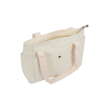 Light canvas tote bag with front pocket, snap flap, and long shoulder handles.