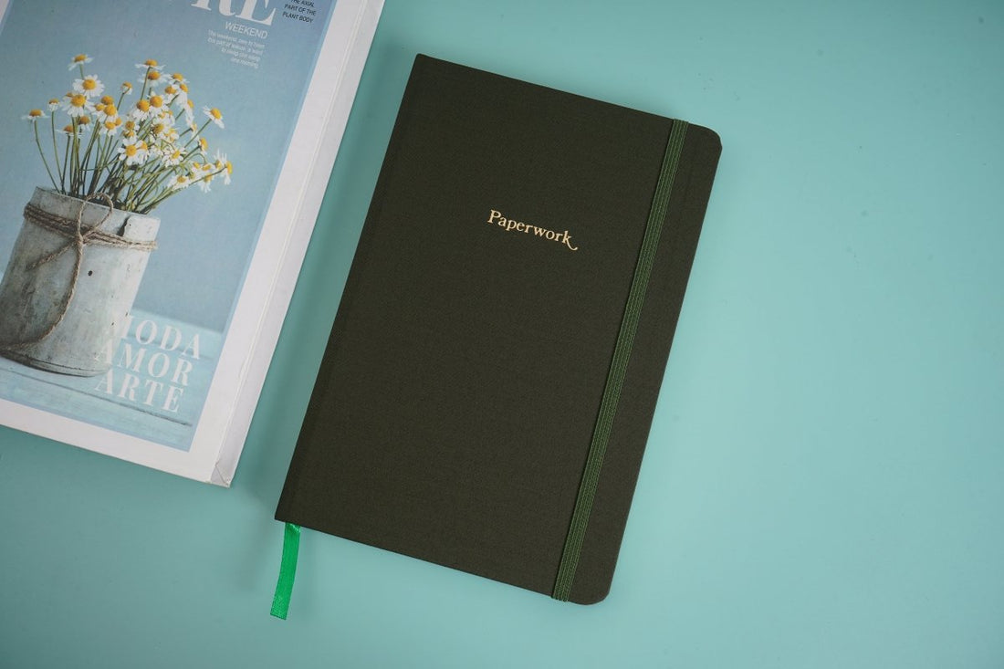 Line notebook with green elastic strap, dark cover