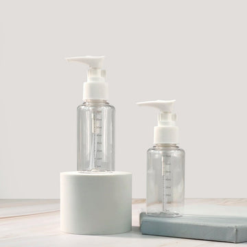 Small clear plastic pump bottles with white dispensers, two bottle set