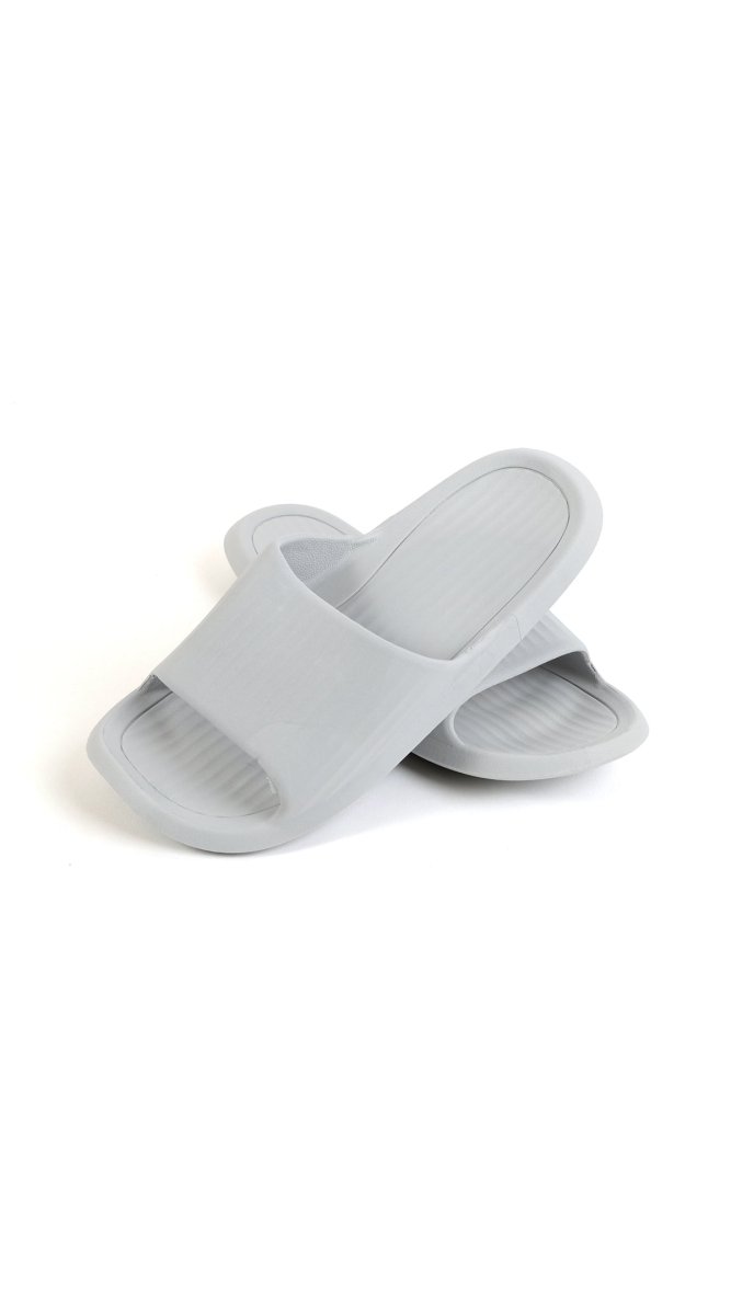 Light gray bathroom slippers at a side angle, ribbed footbeds and open toe