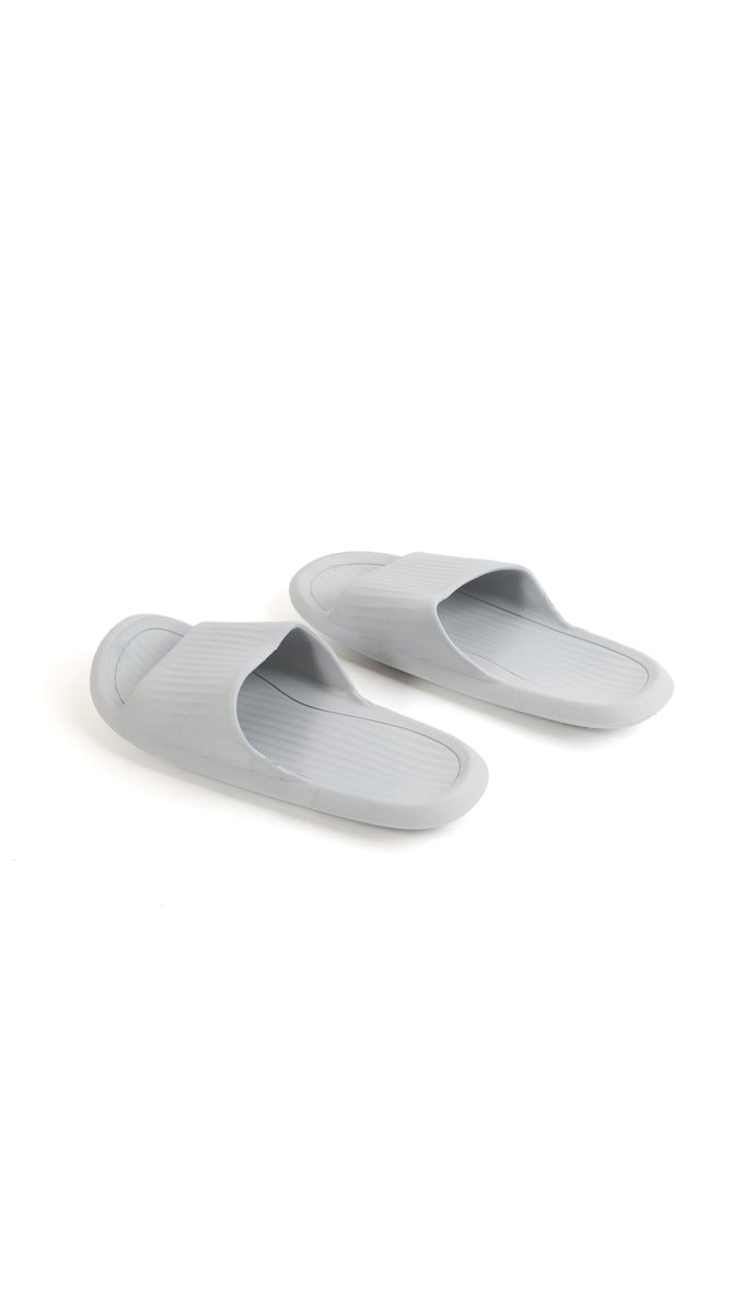 Light gray bathroom slippers side-by-side, ribbed soles and open toe openings
