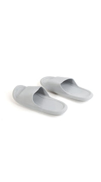 Light gray bathroom slippers side-by-side, ribbed soles and open toe openings