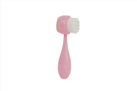 Pink face cleansing brush with white soft bristle head and teardrop handle