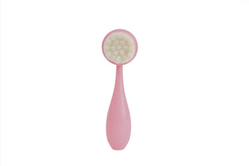 Pink silicone face cleansing brush with soft round bristles and teardrop handle