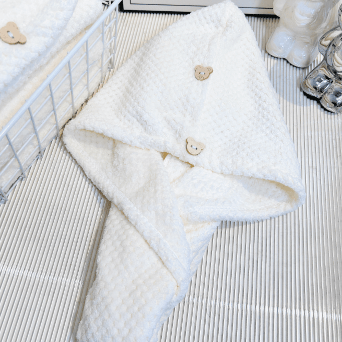 White hair drying towel with bear buttons, folded with textured loop fabric and corner