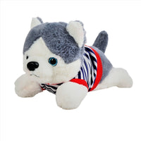 Plush husky puppy toy lying down, gray-and-white fur, striped shirt with red trim