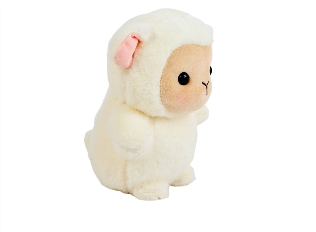 Cream plush lamb stuffed animal in side view, tan face patch and pink ears