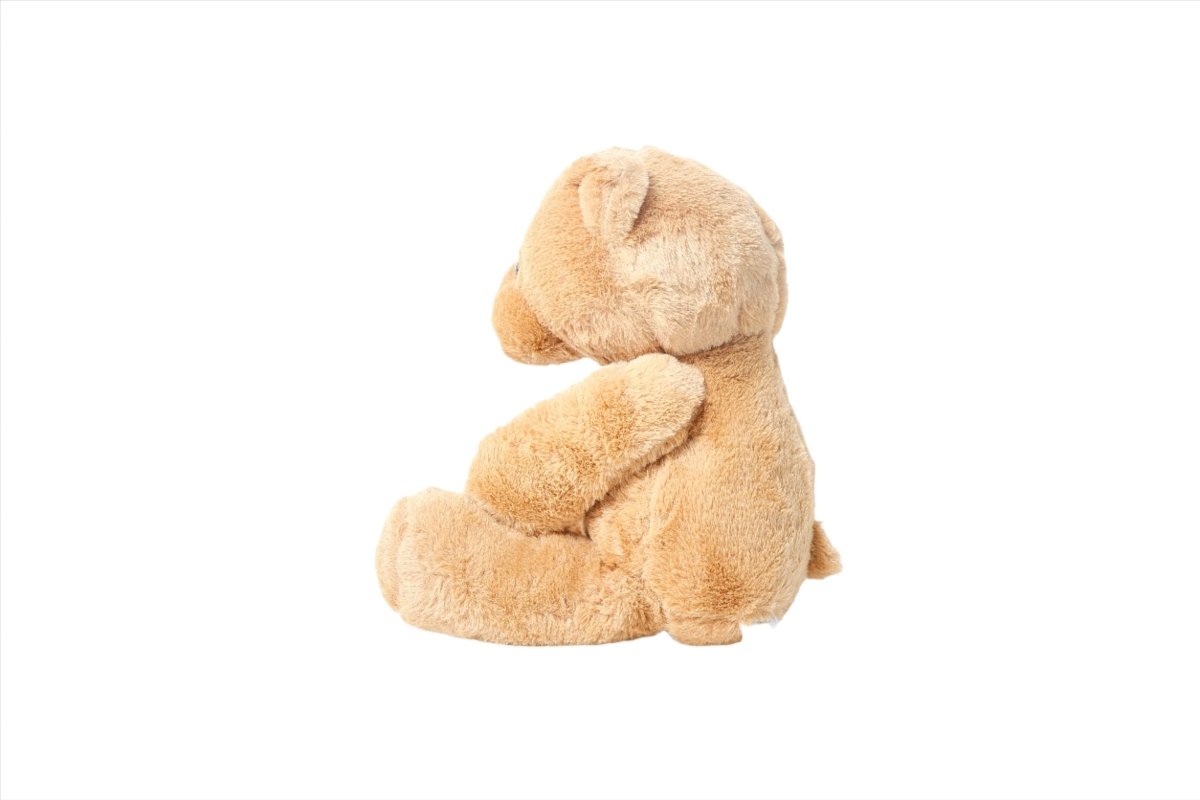 Plush teddy bear in light tan, side view seated with floppy legs