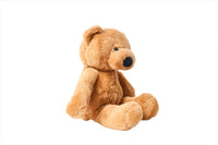 Plush teddy bear in tan with black nose and button eyes, seated with legs forward