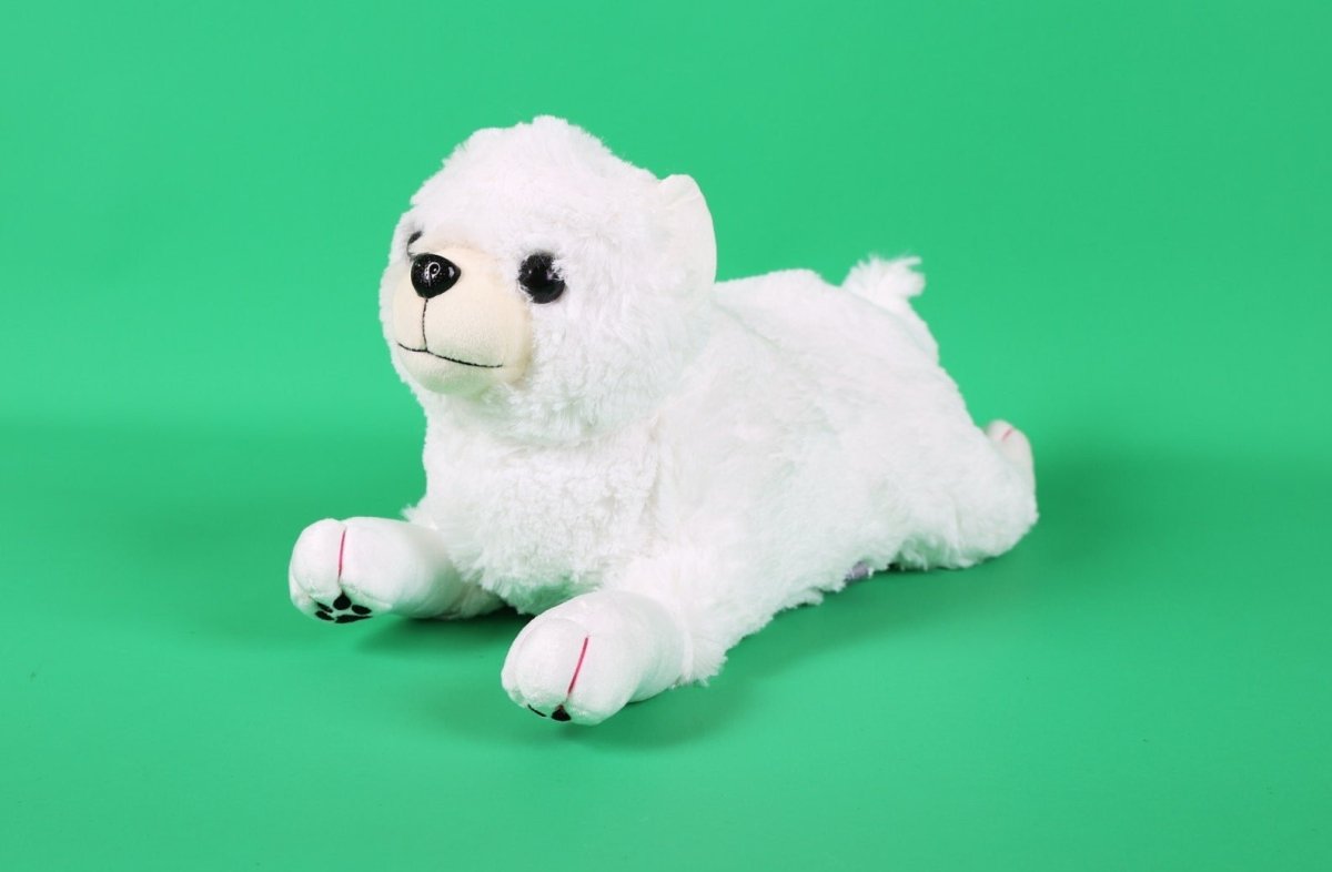 White plush puppy toy with black eyes and nose, lying with front paws forward