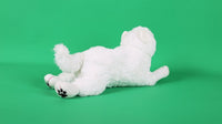 White plush puppy toy lying with tail curled, back visible and paw pads