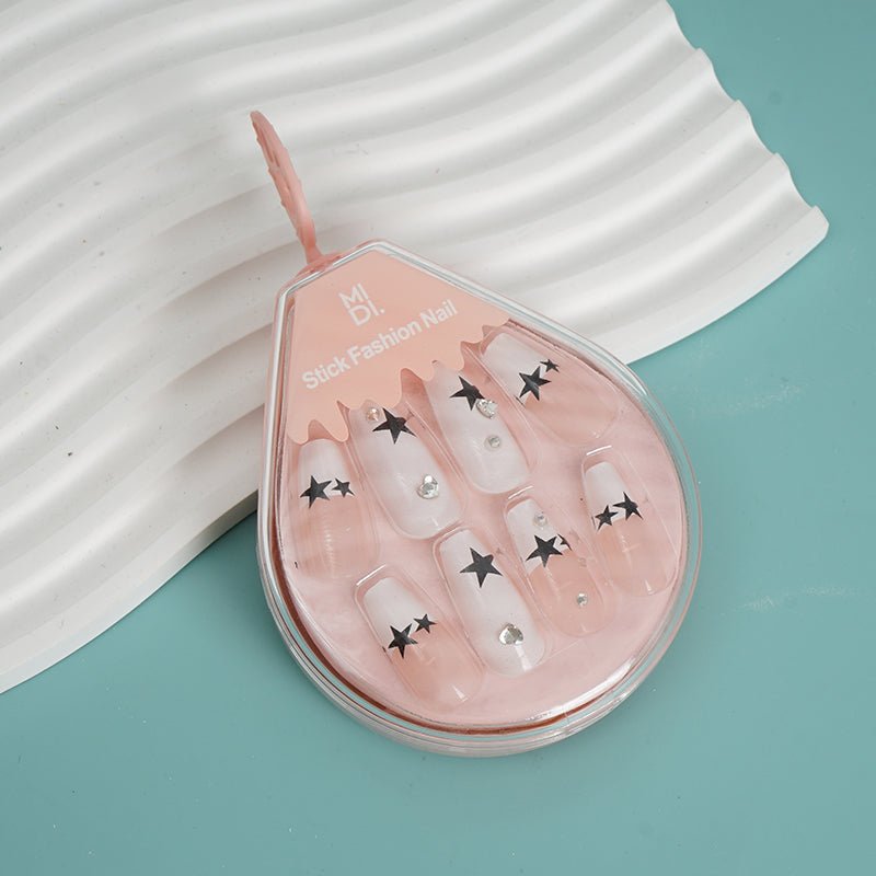 Star Design press-on nails with sheer pink nails, black star motifs and studs
