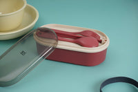 Maroon bento box with open lid and included fork and spoon set