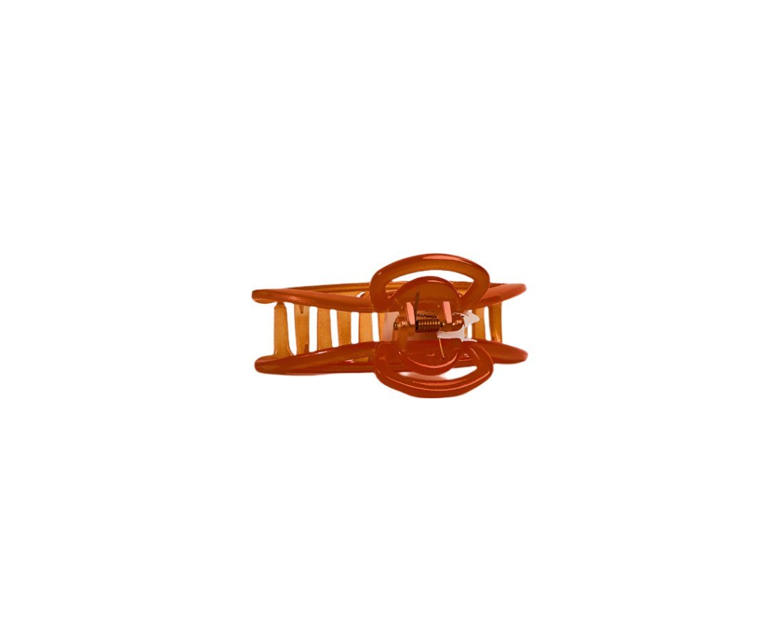 Orange plastic claw hair clip with hinged grip teeth