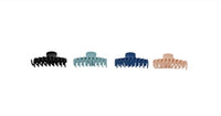 Four claw hair clips in black, light teal, navy blue, and light tan