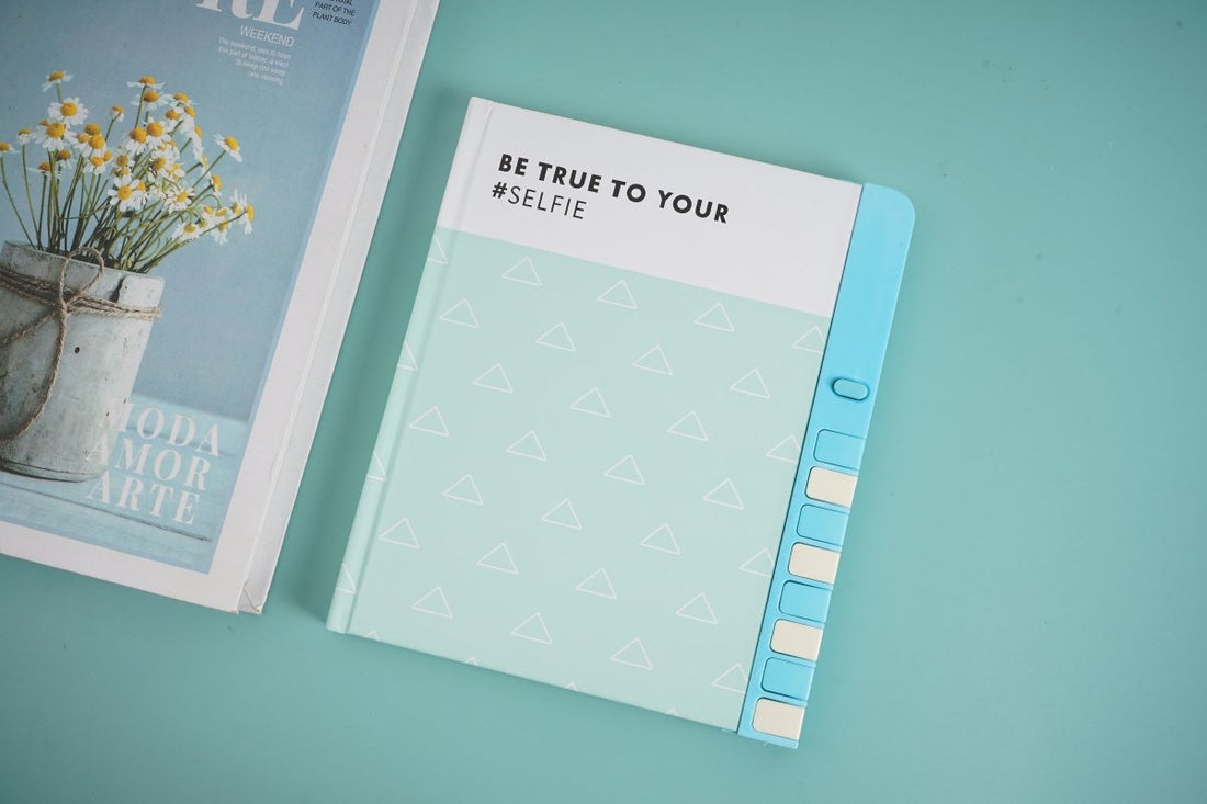 Blue hardback notebook with “Be true to your self” text and triangle pattern cover