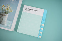 Blue hardback notebook with “Be true to your self” text and triangle pattern cover