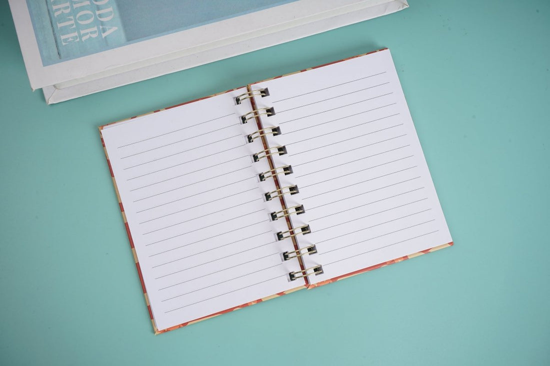 Open spiral notebook with ruled pages and gold coil binding