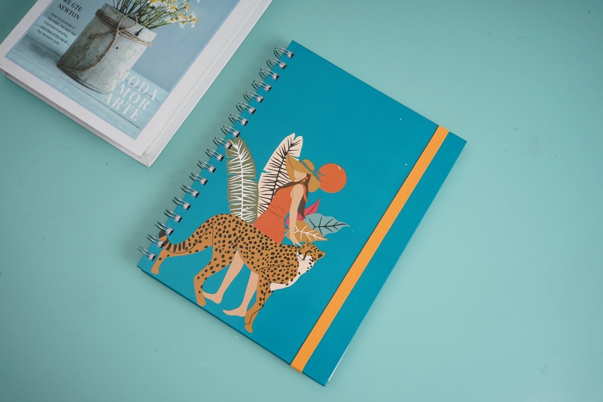 Coil notebook cover with teal background, leopard and dancer illustration, orange spine stripe