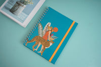 Coil notebook cover with teal background, leopard and dancer illustration, orange spine stripe