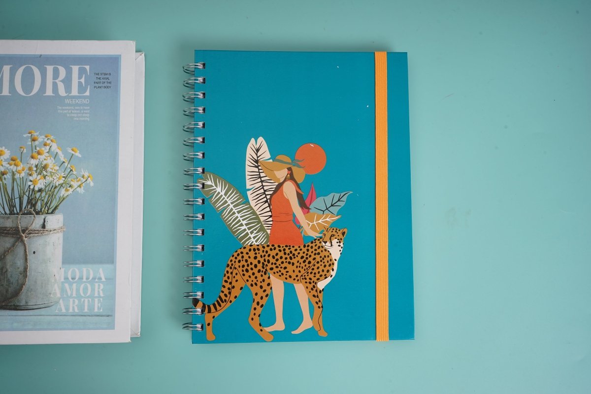 Teal coil notebook with illustrated leopard figure and orange vertical stripe on cover