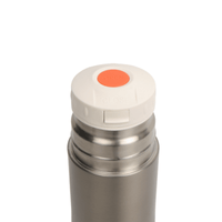 Thermal water bottle lid with orange button and white twist-top cover