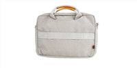 Light gray laptop bag front view with top handle, front panel seam, and small red tag