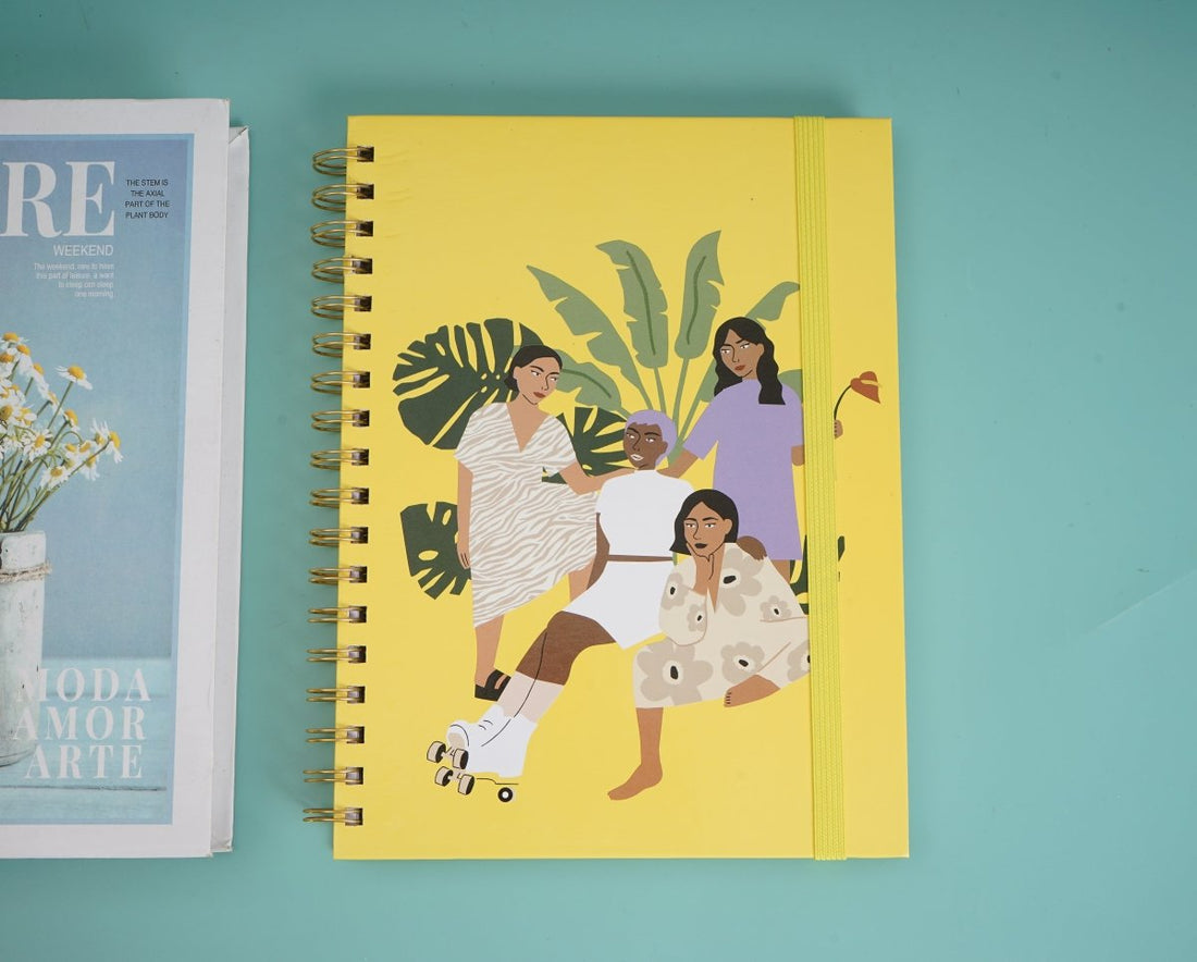 Large coil notebook with yellow cover and colorful figure print