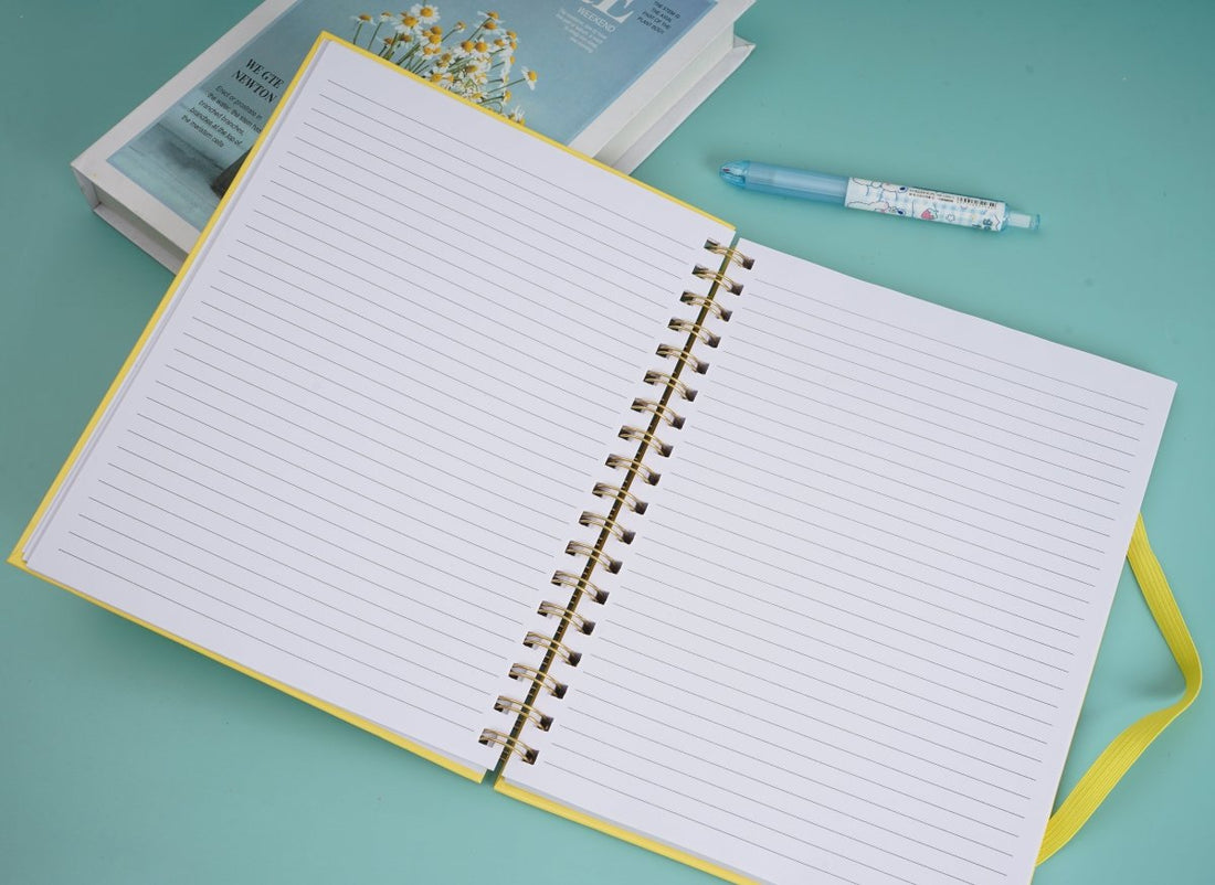 Open large coil notebook with lined pages and gold spiral rings