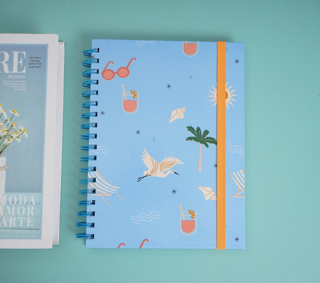 Kids blue spiral notebook with beach-themed cover print and orange spine