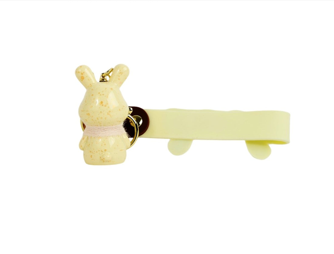 Rabbit keychain with 'SUNSET' charm on pale yellow strap and small key ring