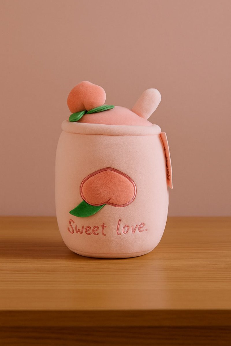 Pink plush cup toy with peach face and green leaves, embroidered “Sweet love.”