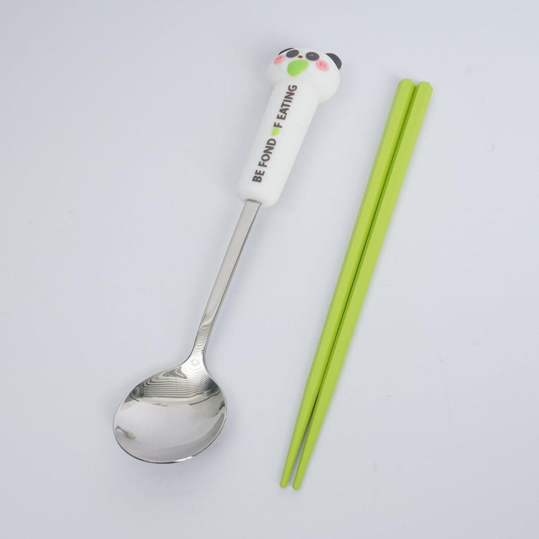 Animal-themed spoon with character handle and green chopsticks, matching cutlery set