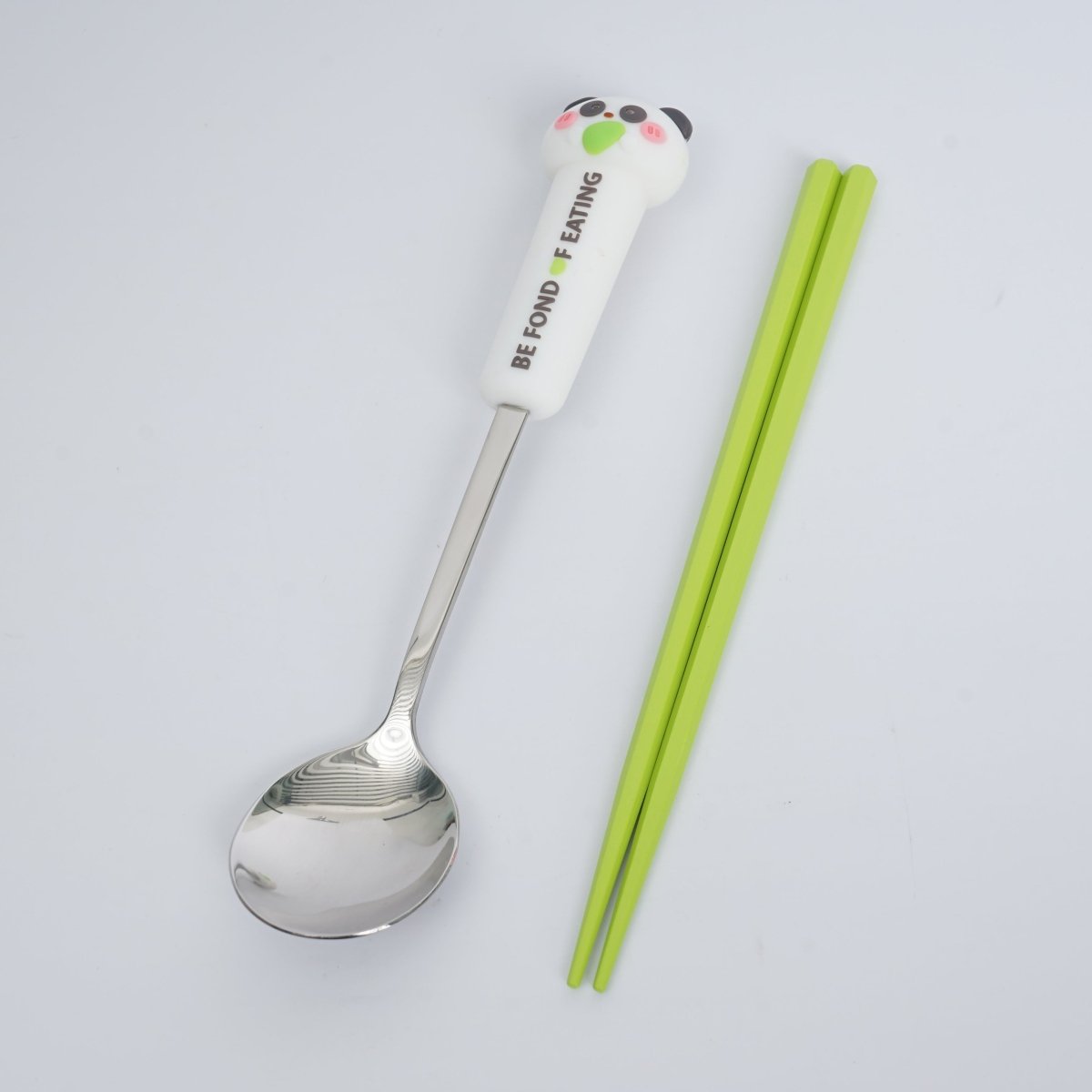 Animal-themed spoon with character handle and green chopsticks, matching cutlery set