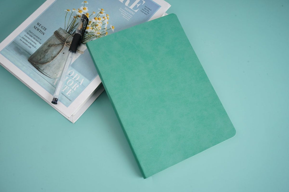 Teal ruled notebook with plain cover, closed.