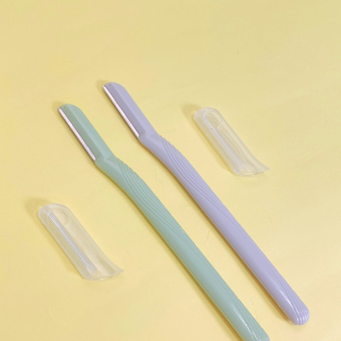 Facial razors with protective caps set: light blue and lavender razors plus two clear caps