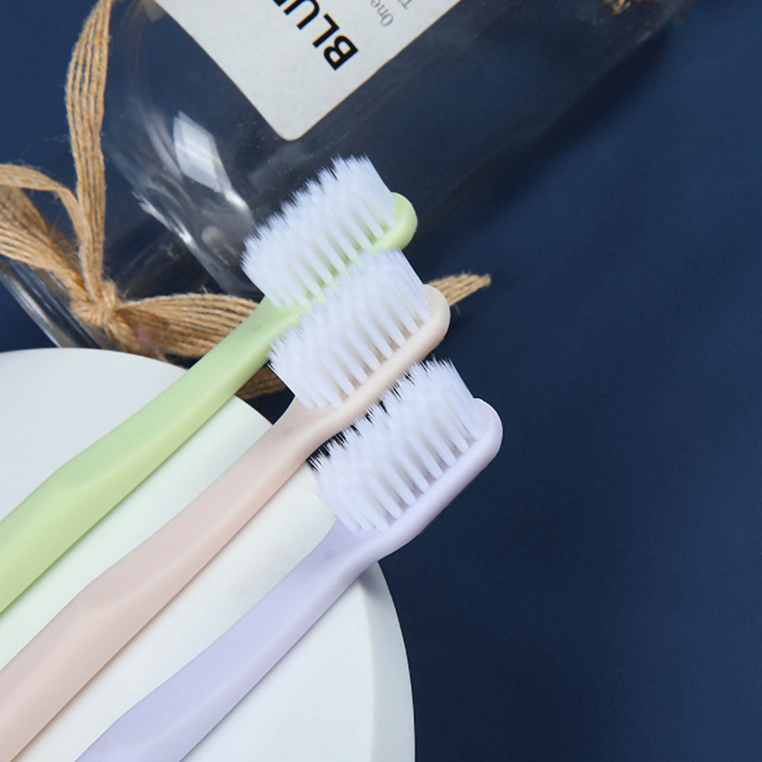 4-pack toothbrush set with white bristles on green, pink, and light purple handles