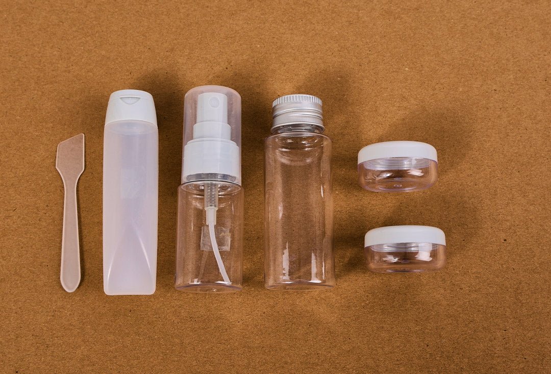 Travel size empty bottle set with clear bottles, white pump, and travel jars