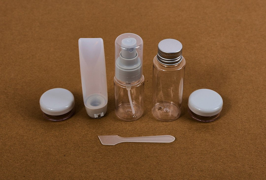 Travel size empty bottle set: clear bottles with white caps and small pump bottle
