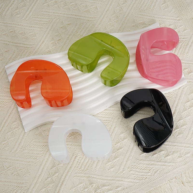 Assorted plastic hair clips in green, white, black, orange, and pink