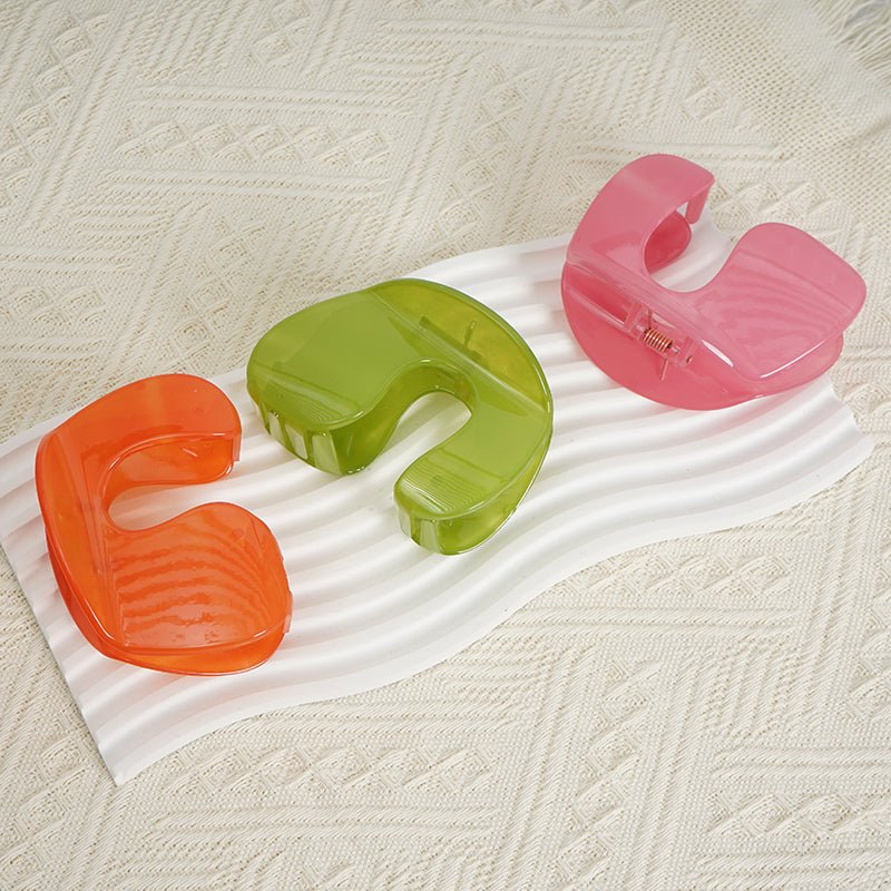 Assorted plastic hair clips in orange, green, and pink