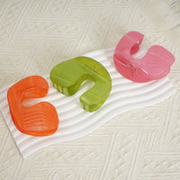 Assorted plastic hair clips in orange, green, and pink
