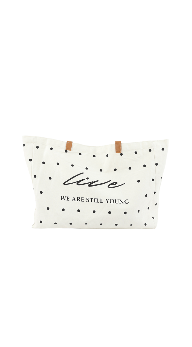 White tote bag with black polka dots, brown handles, front logo text