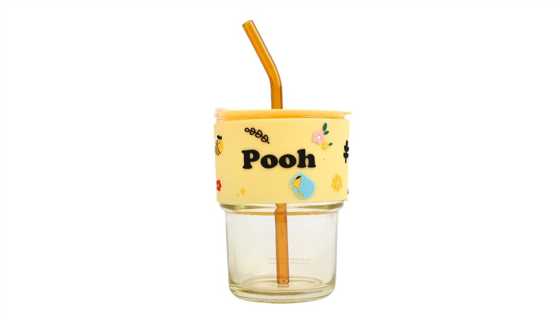 Winnie the Pooh glass cup with straw, front view with Pooh graphic yellow sleeve